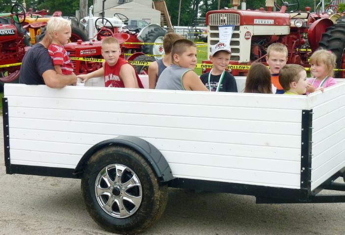 Wagon of Passengers being pulled by vintage John Deere Tractor in Sunday's Parade at the fair