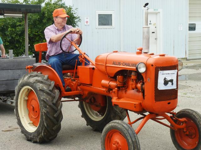 Orange 1947 Allis Chalmers B Tractor pulling a wagon in Sunday's parade at the fair