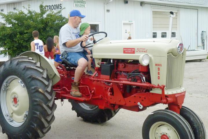Red and Cream-colored Ford Model 960 Tractor in Monday's parade at the fair