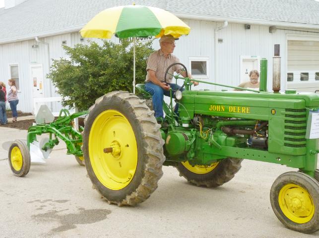 Vintage John Deere Tractor with a John Deere Shade Umbrella pulling a John Deere Plough in Monday's parade at the fair